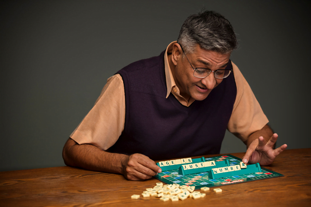A senior man playing a board game, showcasing creativity in active ageing.