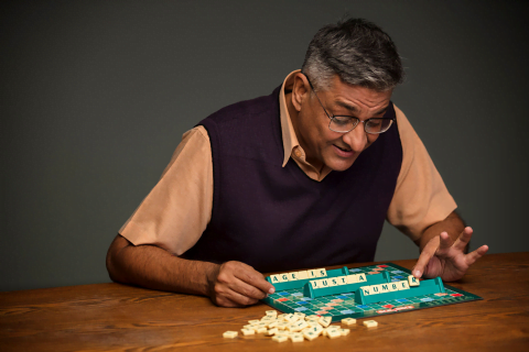 A senior man playing a board game, showcasing creativity in active ageing.